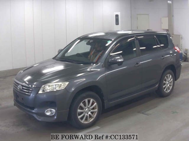 A grey sports car speeding down a highway at night.