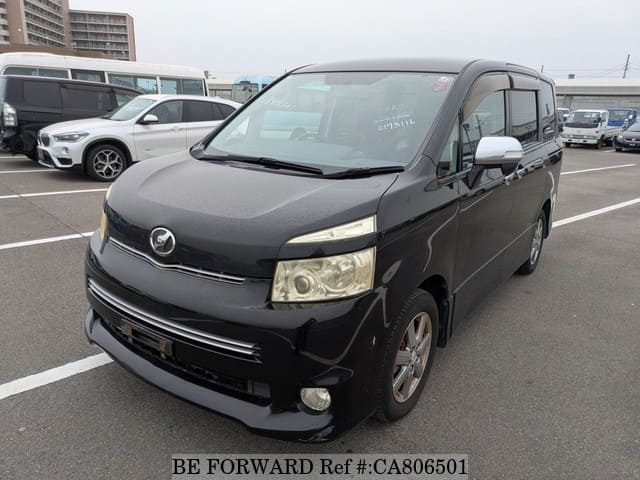 A grey JDM sports car speeding down a highway at night.
