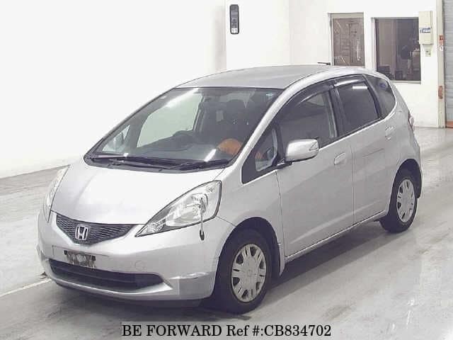 A grey JDM sports car speeding down a highway at night.