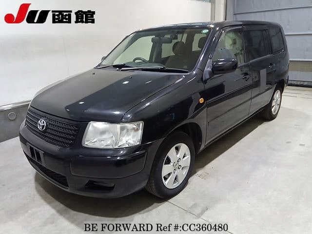 A grey sports car speeding down a highway at night.
