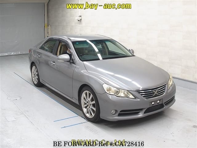A grey JDM sports car speeding down a highway at night.