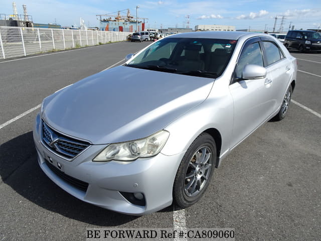 A grey JDM sports car speeding down a highway at night.