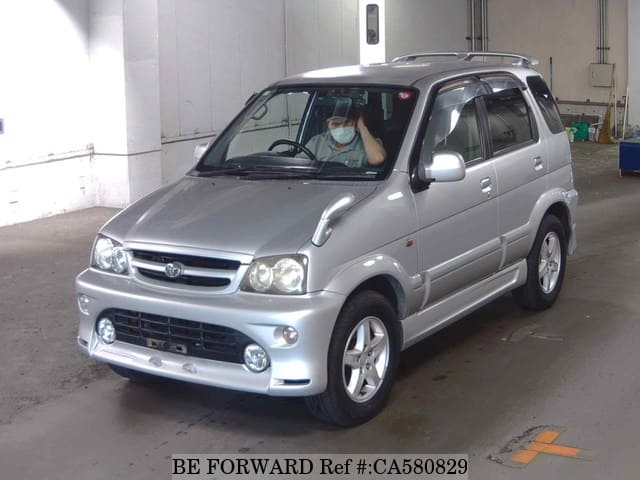 A grey JDM sports car speeding down a highway at night.
