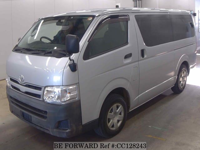 A grey sports car speeding down a highway at night.