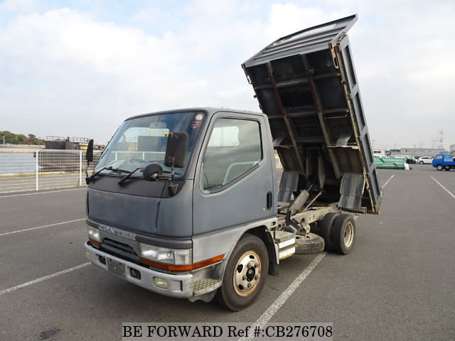 A grey JDM sports car speeding down a highway at night.