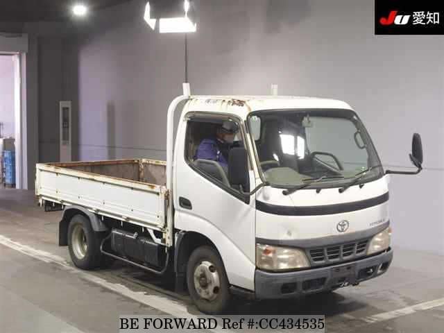 A grey JDM sports car speeding down a highway at night.