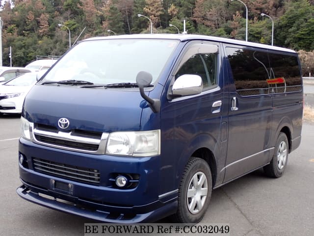 A grey sports car speeding down a highway at night.