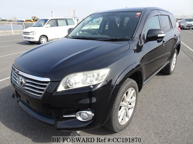 A grey sports car speeding down a highway at night.
