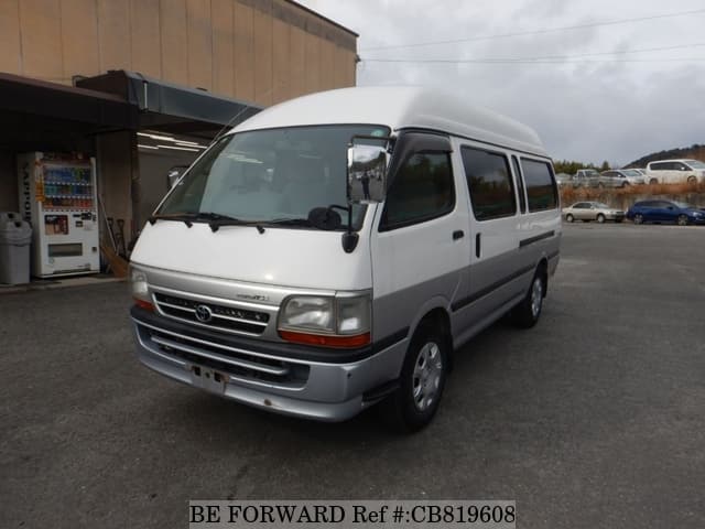 A grey JDM sports car speeding down a highway at night.