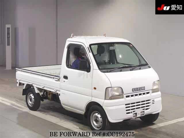 A grey sports car speeding down a highway at night.