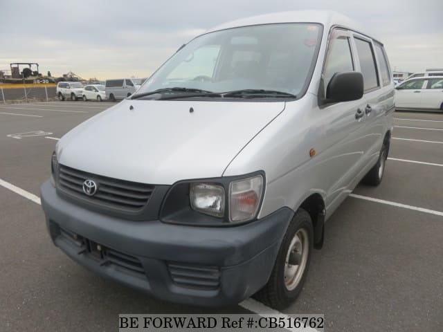 A grey JDM sports car speeding down a highway at night.