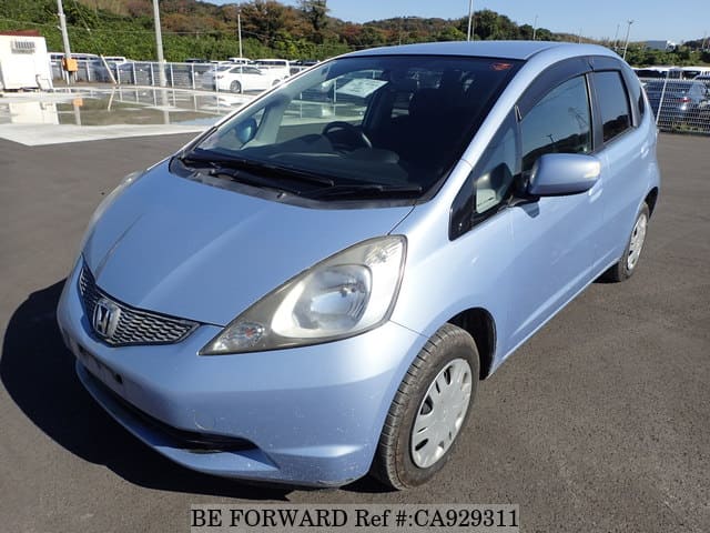 A grey JDM sports car speeding down a highway at night.