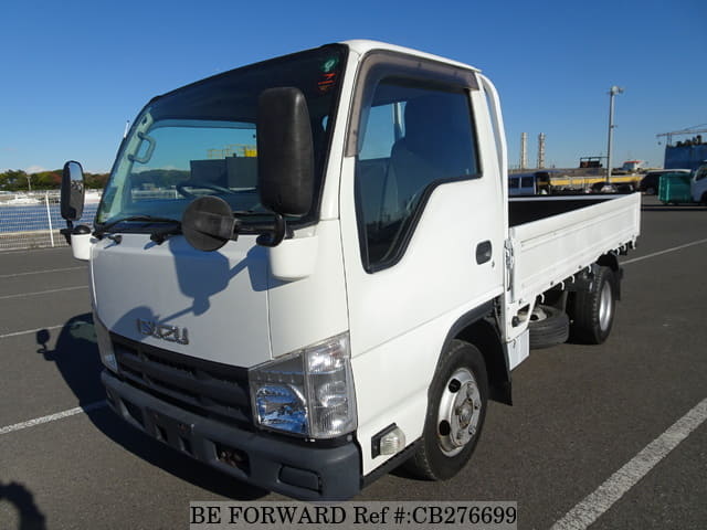 A grey JDM sports car speeding down a highway at night.