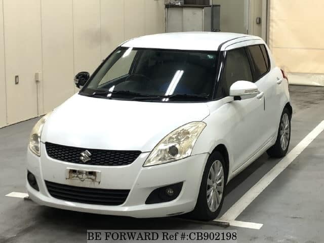 A grey JDM sports car speeding down a highway at night.