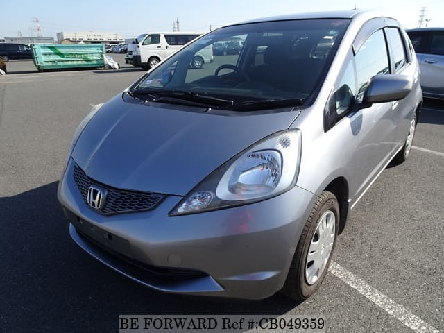 A grey sports car speeding down a highway at night.