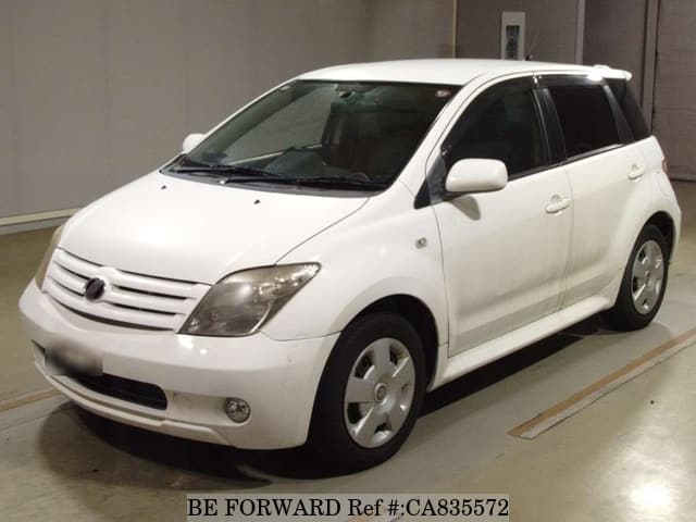 A grey JDM sports car speeding down a highway at night.