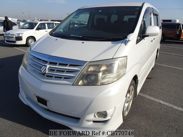 A grey JDM sports car speeding down a highway at night.