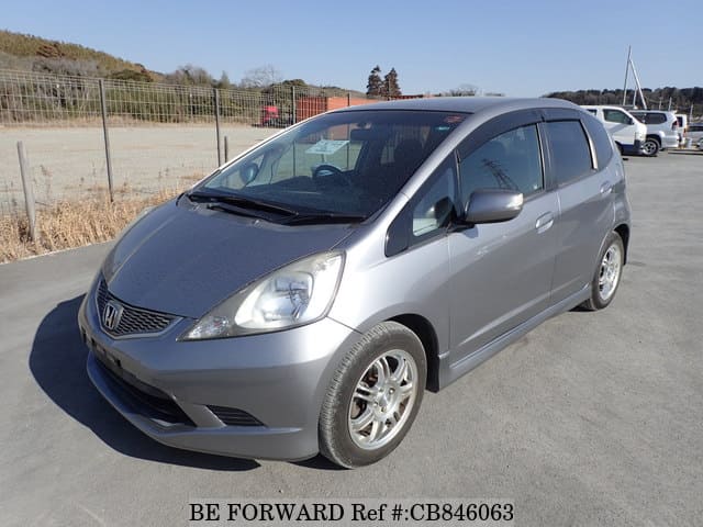 A grey JDM sports car speeding down a highway at night.