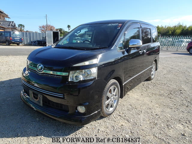 A grey JDM sports car speeding down a highway at night.