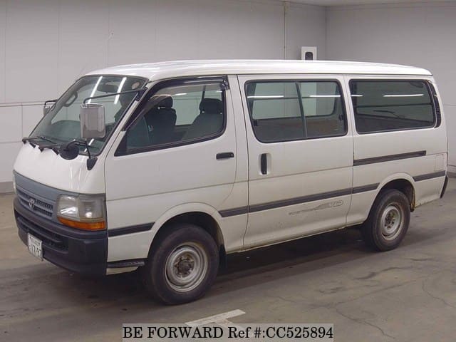 A grey sports car speeding down a highway at night.