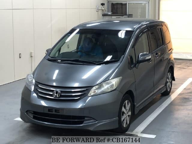 A grey JDM sports car speeding down a highway at night.