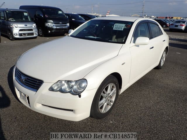 A grey sports car speeding down a highway at night.