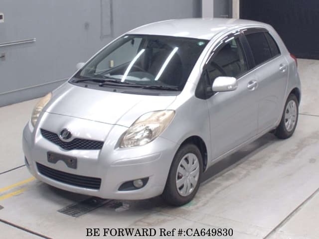 A grey JDM sports car speeding down a highway at night.