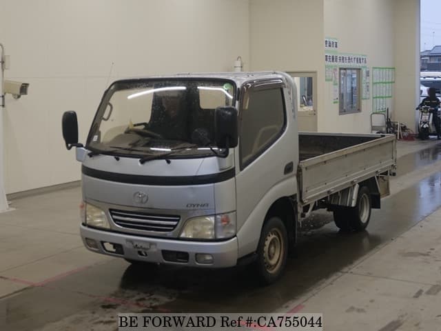 A grey JDM sports car speeding down a highway at night.
