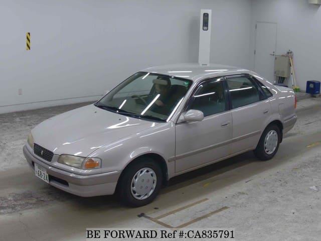 A grey JDM sports car speeding down a highway at night.