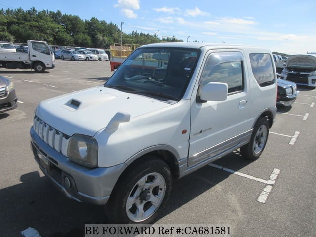 A grey JDM sports car speeding down a highway at night.