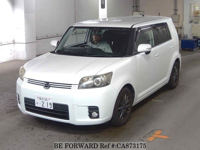 A grey JDM sports car speeding down a highway at night.