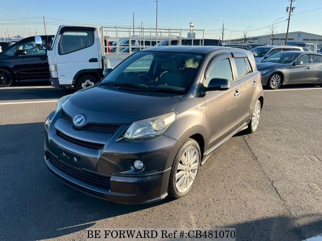 A grey JDM sports car speeding down a highway at night.