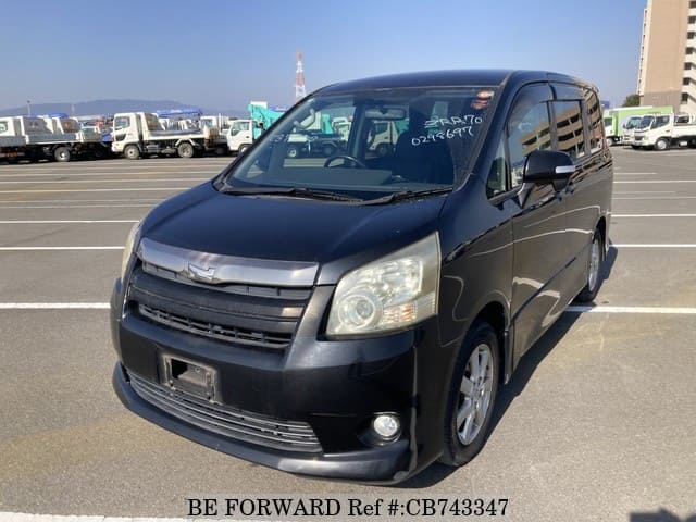 A grey JDM sports car speeding down a highway at night.