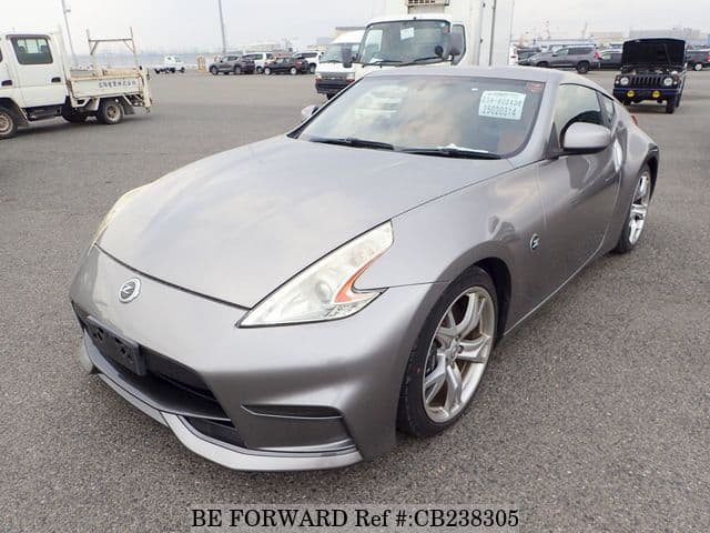 A grey JDM sports car speeding down a highway at night.