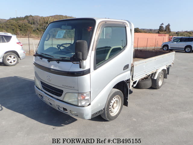 A grey JDM sports car speeding down a highway at night.