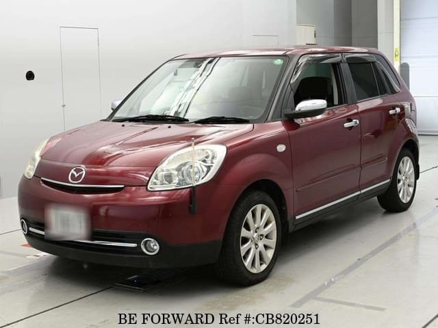 A grey JDM sports car speeding down a highway at night.