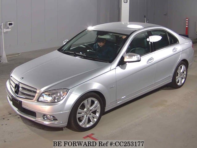 A grey sports car speeding down a highway at night.