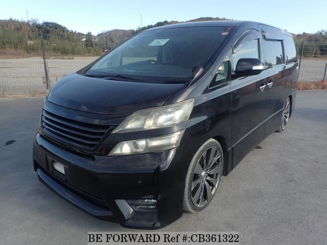 A grey JDM sports car speeding down a highway at night.