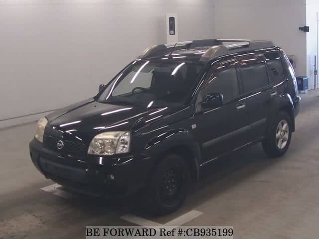 A grey sports car speeding down a highway at night.