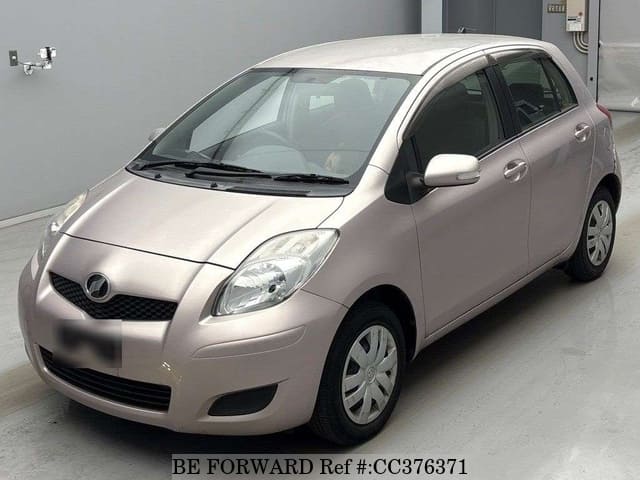 A grey sports car speeding down a highway at night.