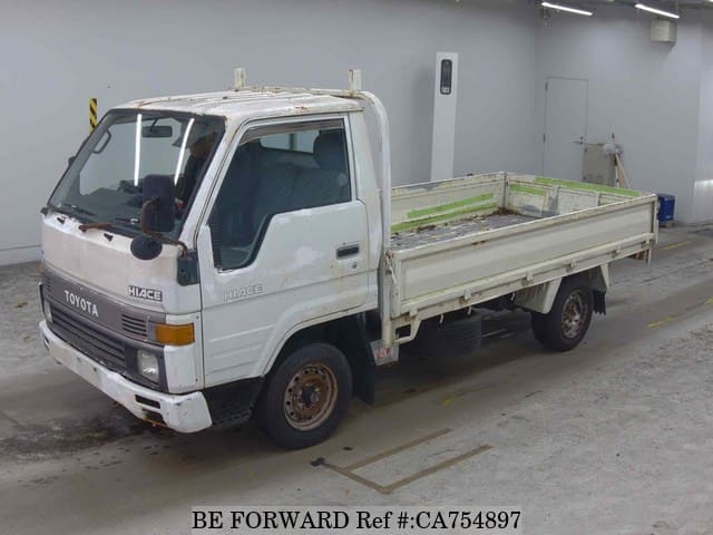 A grey JDM sports car speeding down a highway at night.