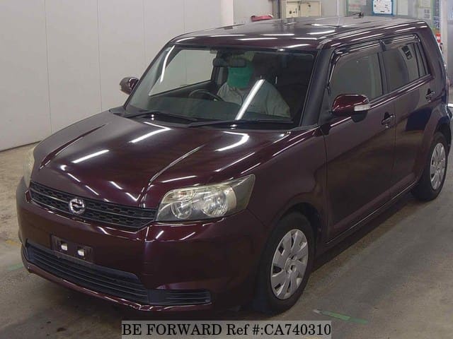 A grey JDM sports car speeding down a highway at night.