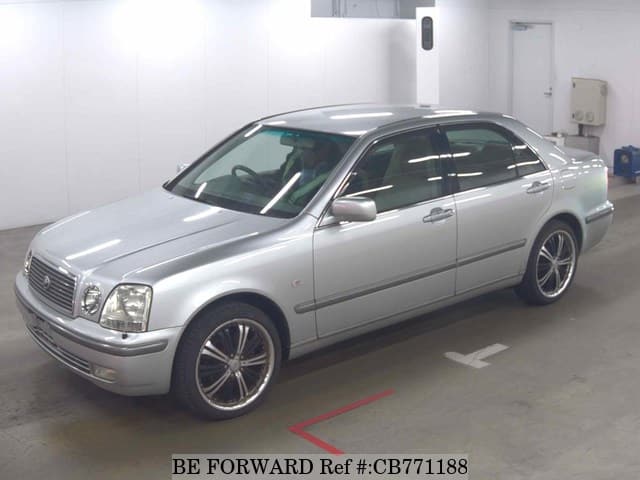 A grey JDM sports car speeding down a highway at night.