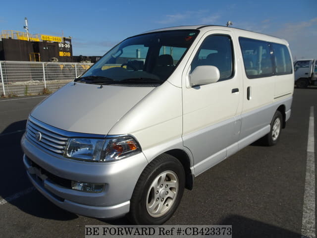 A grey sports car speeding down a highway at night.