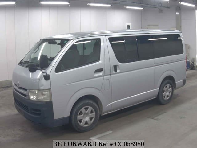 A grey sports car speeding down a highway at night.