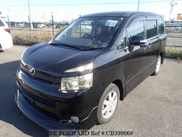 A grey JDM sports car speeding down a highway at night.