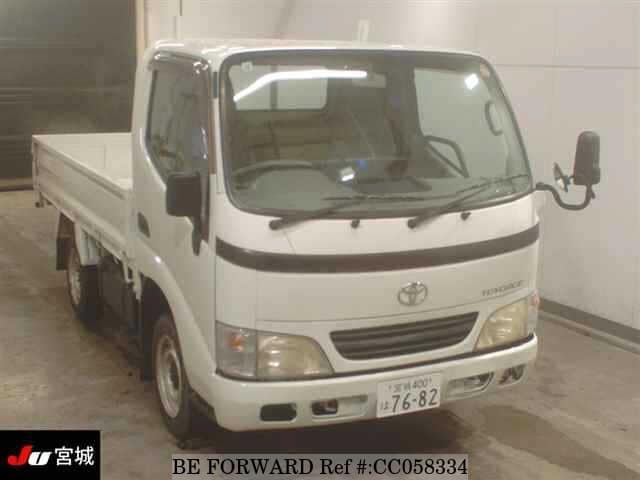 A grey sports car speeding down a highway at night.