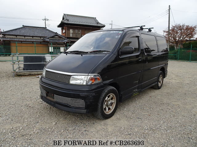 A grey JDM sports car speeding down a highway at night.
