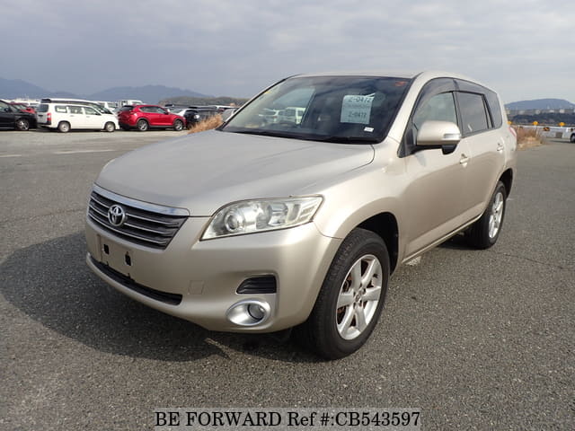 A grey sports car speeding down a highway at night.