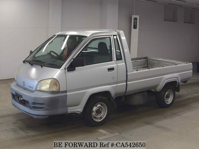A grey JDM sports car speeding down a highway at night.